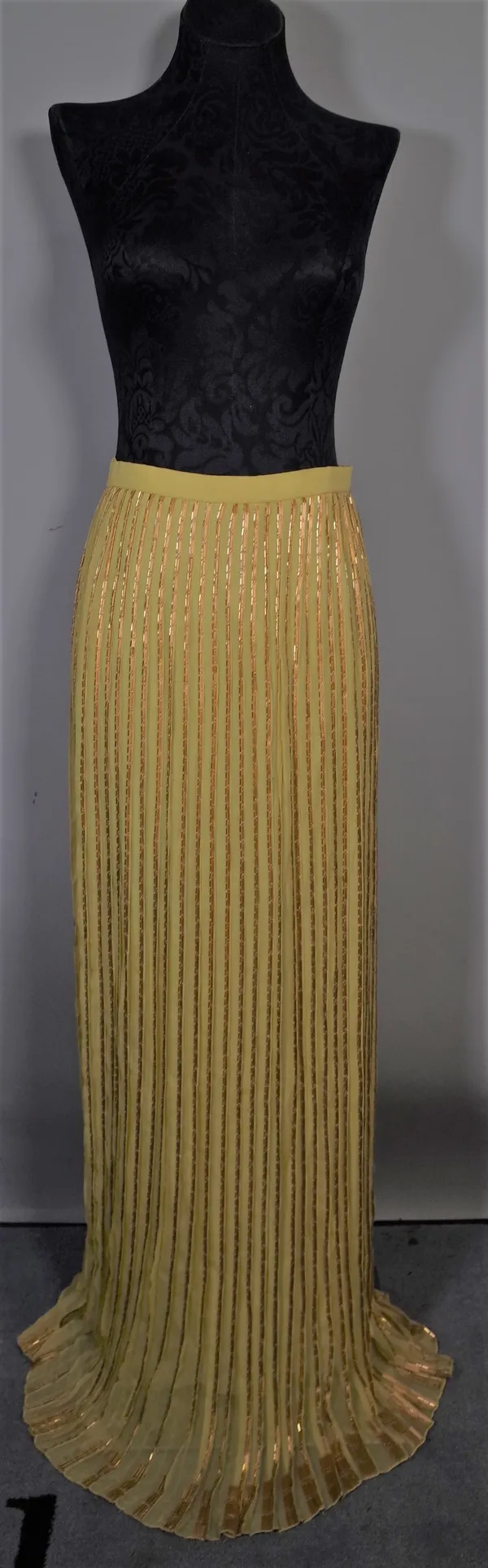 Christian Dior Haute Couture, a yellow and gold beaded silk evening skirt and a brown pin striped wide leg trouser suit with asymmetrical buttoned jac