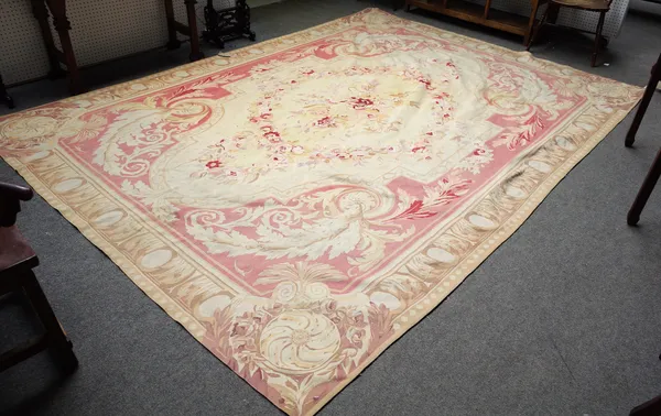 An Aubusson carpet, the cream field centred by a large floral bouquet and garland surround, pink outer surround, an oval motif border, 370cm x 265cm.