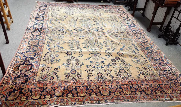 A Sarough carpet, Persian, the pale madder field with a stylised floral cross, supported by other floral sprigs and sprays, a dark indigo palmette of