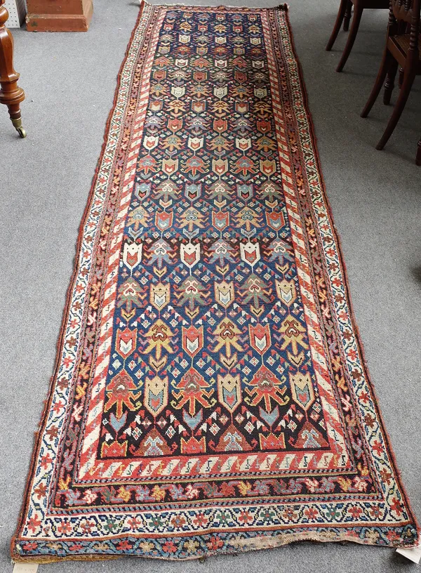 A Gendje Kazakh runner, Caucasian, the indigo field with rows of stylised flowerhead motifs, banded inner border, 398cm x 100cm.