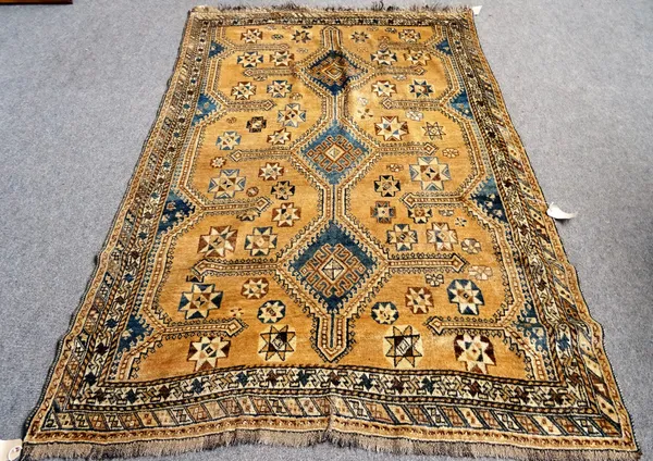 A Shiraz rug, Persian, the brown field with three connecting indigo diamonds supported by stars, two borders, 242cm x 160cm.