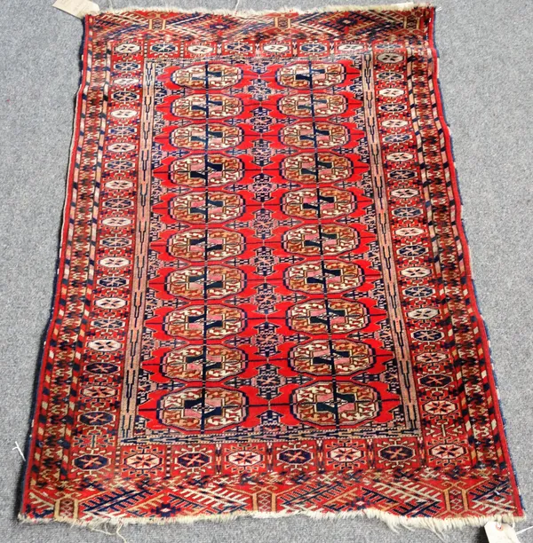 A Tekke Turkman rug, the madder field with two columns of ten guls, a sunburst border, 120cm x 82cm.