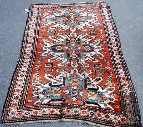 A Chelaberd Kazakh rug, Caucasian, the madder field with three bold ivory medallions, supporting mirror motifs, an ivory star and bracket border, 233c