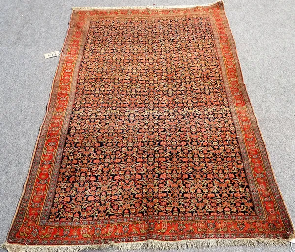 A fine Senneh rug, Persian, the black field with an allover fine herate design, the madder palmette and vine border, 186 x 130cm.