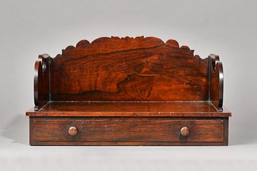 A William IV rosewood table top book stand with shaped gallery over single drawer, 44cm wide x 23cm high. Illustrated.