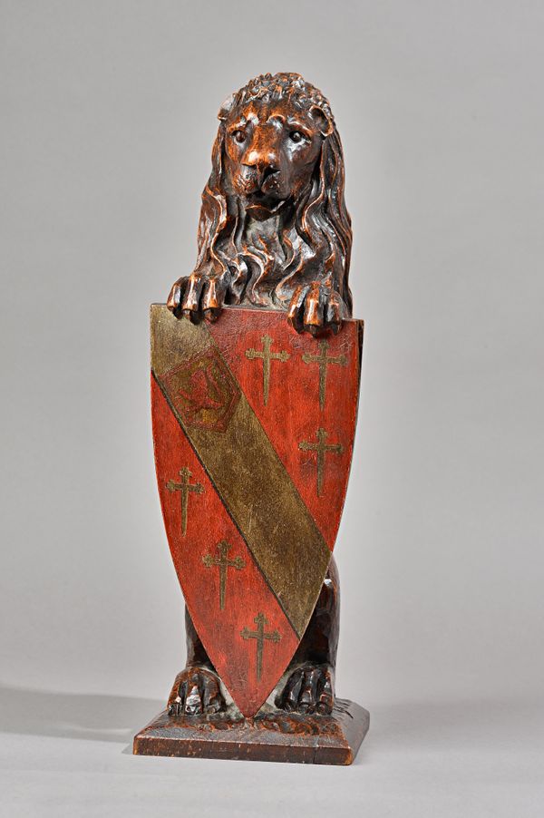 A 19th century carved figure of a sergeant lion, holding an armorial shield, 50cm high. Illustrated.