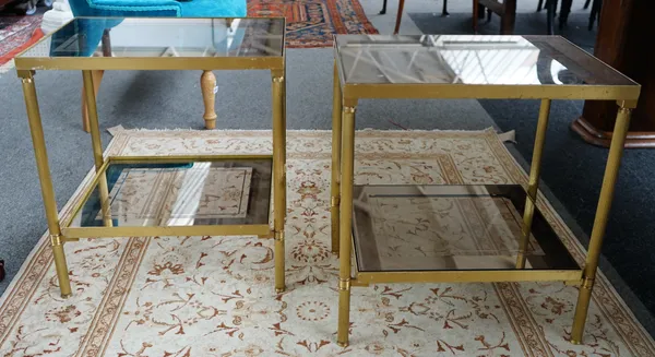 A pair of mid-20th century rectangular lacquered brass and glass two tier occasional tables, on reeded supports, 50cm wide x 55cm high, (2).