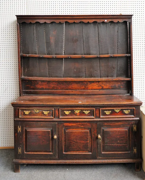 An 18th century oak dresser, the enclosed two tier plate rack over three drawers and cupboards on block feet, 140cm wide x 183cm high.