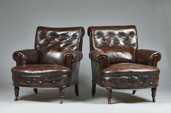 A pair of late 19th century French brown leather upholstered easy armchairs, on turned mahogany supports, 85cm wide x 88cm high, (2).Illustrated.