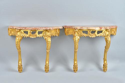 A pair of 19th century console tables, each with serpentine marble top,over carved and pierced frieze on pair of opposing 'C' scroll supports, 78cm wi