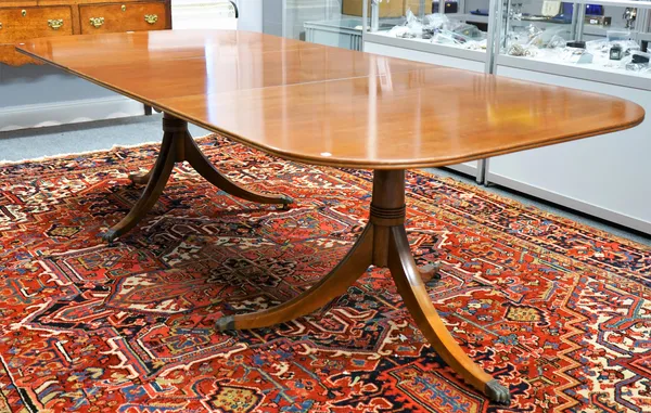 A George III style mahogany twin pedestal extending dining table, on six downswept supports, one extra leaf, 116cm wide x 182cm long x 250cm long full