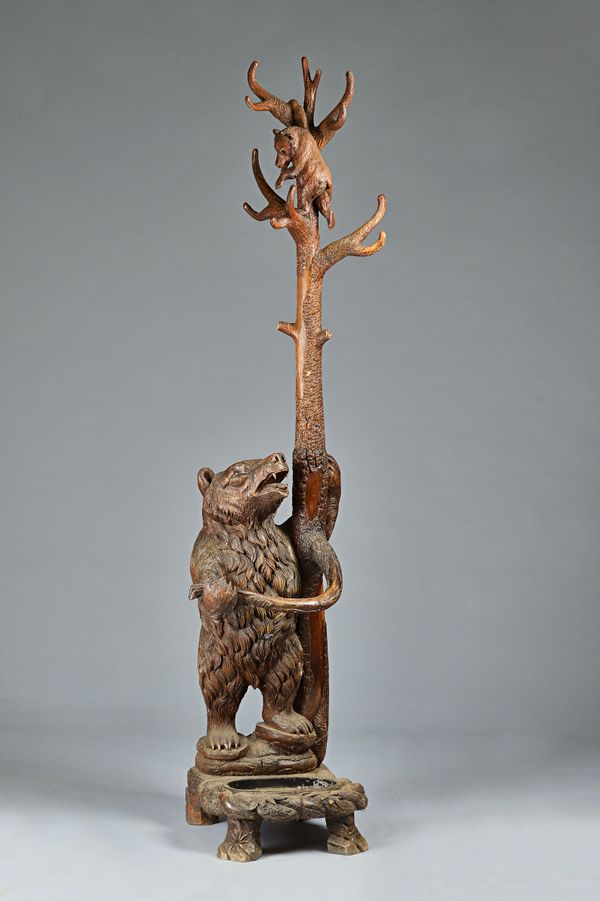 A Black Forest carved pine/linden wood stick and coat stand in the form of a bear and her cub, 42cm wide x 200cm high.Illustrated.