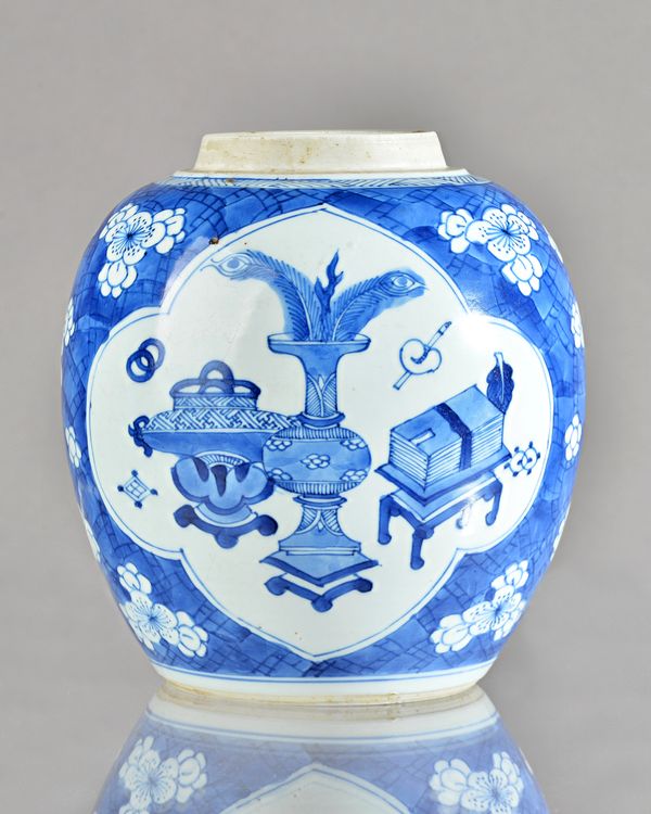 A Chinese blue and white oviform jar, probably Kangxi, painted with two barbed panels enclosing precious objects against a `cracked ice' ground, 17.5c