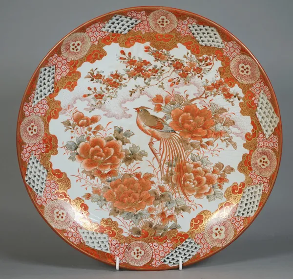 A Japanese Kutani dish, Meiji period, painted with a long-tailed bird perched in branches of flowering peony, 36.5cm. diameter.