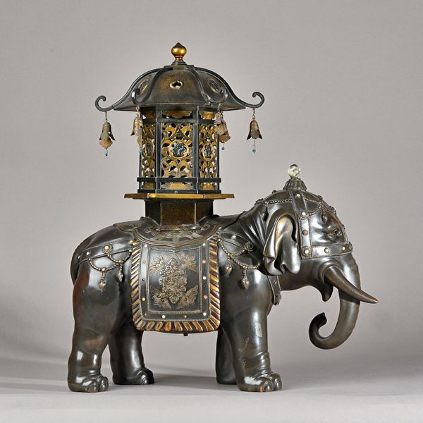 A large Japanese bronze figure of a caparisoned elephant by Genryusai Seiya, Meiji period, modelled standing four-square, with details inlaid in colou