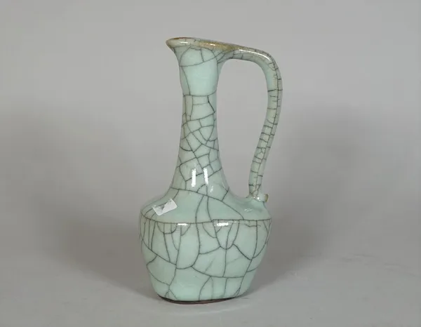 A small Chinese guan-type celadon glazed ewer, the bulbous body below a slender waisted neck and loop handle, 12.5cm. high.