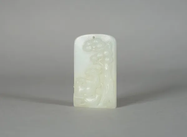 A Chinese white jade rectangular pendant, Qing Dynasty, carved with two goats beneath a pine tree, 5.5cm. high.