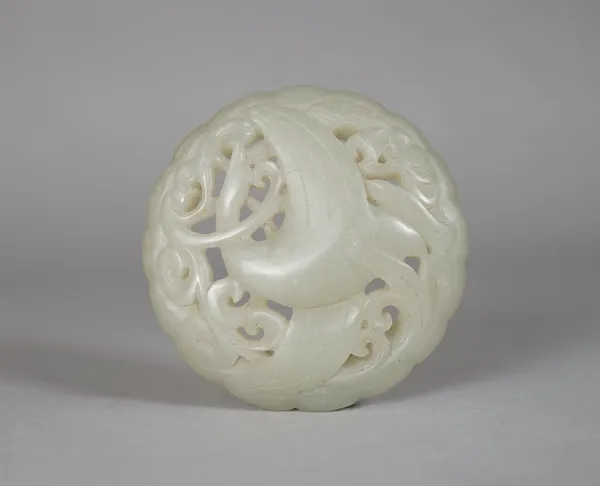 A Chinese pale celadon jade circular plaque, Ming Dynasty or later, pierced and carved with a bird amongst lotus and scrolls, 6cm. diameter.