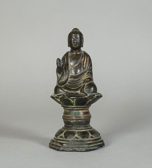 A small Chinese bronze seated Buddha, probably Liao dynasty, seated on a lotus pedestal in dhyanasana, with right hand in abhayamudra and with left ha