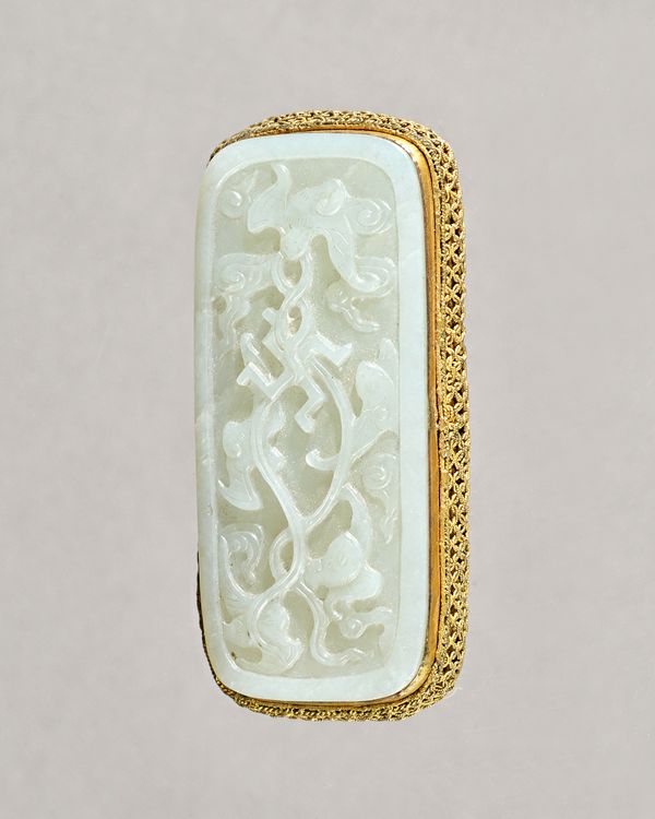 A Chinese cealdon jade rounded rectangular plaque, Qing dynasty, carved with bats, a swastika and scrolls, mounted as a belt buckle with gilt-metal fi