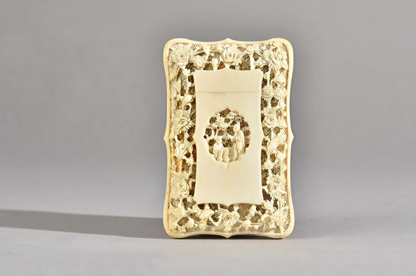 A Canton ivory card case, second half 19th century, of shaped rectangular form, carved with two central figures against a ground filled with flowers,