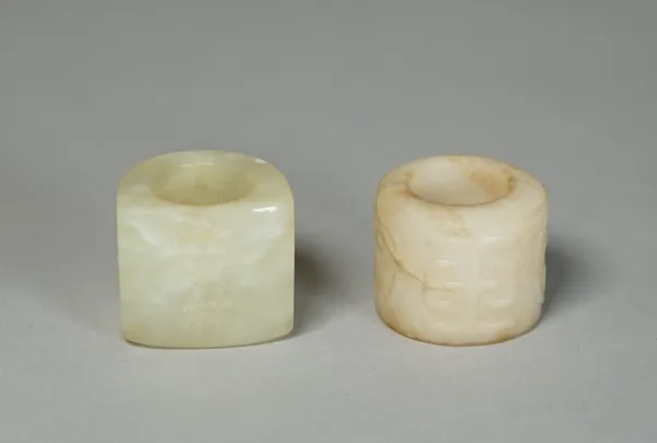 Two Chinese jade archer's rings, one carved with two chracters, the other with characters alternating with stylised animals, each approx. 3cm. high, (