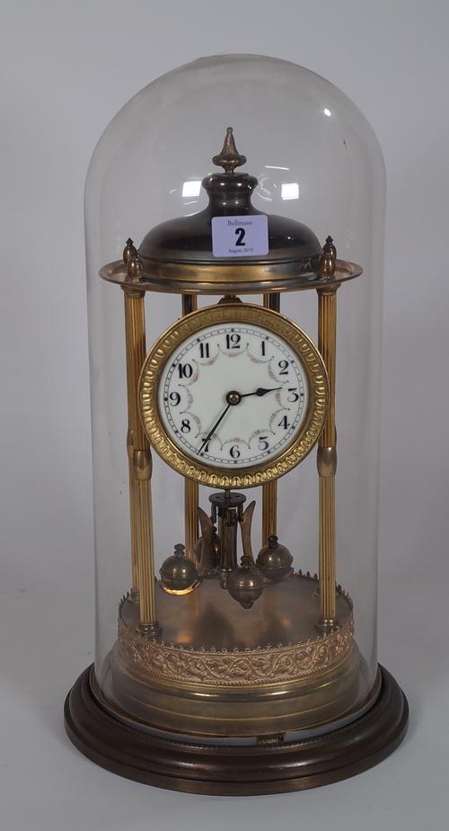 A Torsion anniversary clock, within a glass dome case, 45cm high.