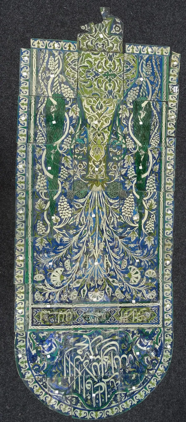 A panel of reverse painted glass, late 19th/20th century, of arched form, the design after a Damascus tile panel, with inscription and date AH1192/ AD