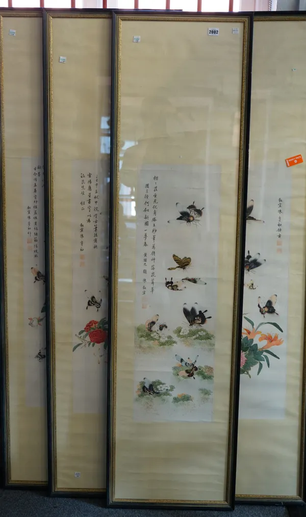 Four Chinese pictures, 20th century, watercolour over a printed outlines, depicting butterflies amongst flowers beside rows of text, images 84cm. by 2