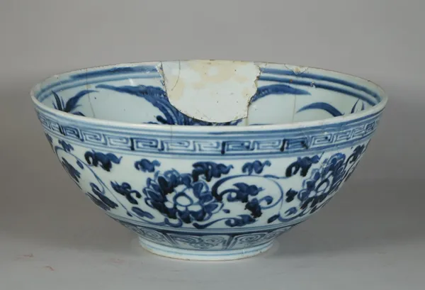 A Chinese blue and white bowl, Ming dynasty, 17th century, freely painted in the interior with flowers and grasses, the exterior painted with lotus me