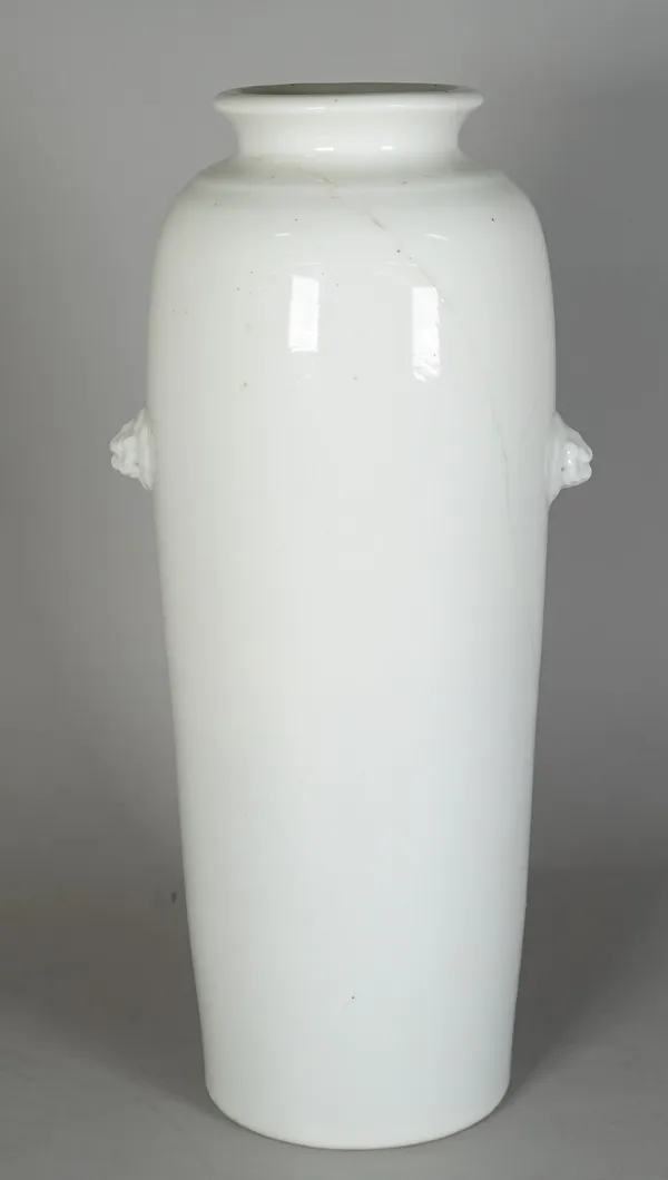 A Chinese blanc-de-chine sleeve vase, 17th century, of tapered cylindrical form with two buddhist lion-mask handles, one side lightly incised with a p