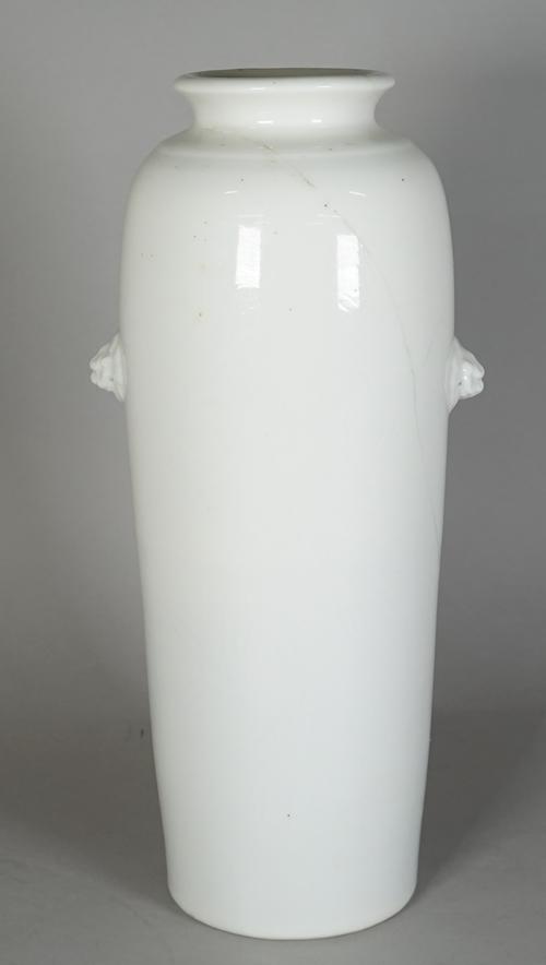A Chinese blanc-de-chine sleeve vase, 17th century, of tapered cylindrical form with two buddhist lion-mask handles, one side lightly incised with a p