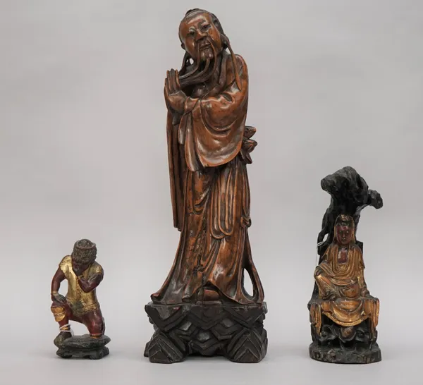 A Chinese carved wood figure of a man, 20th century, standing in long robes, 43cm. high; also a small carved wood and painted group of a seated Guanyi