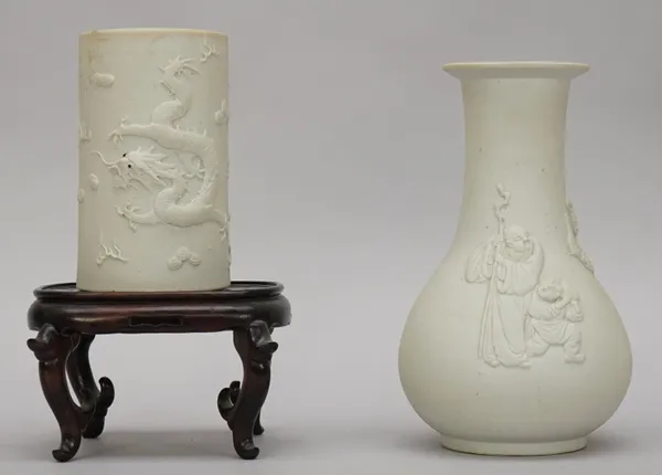 A Chinese white biscuit porcelain pear shaped vase, late 19th/20th century, moulded in relief with three figures and a deer, 20cm. high, wood stand; a