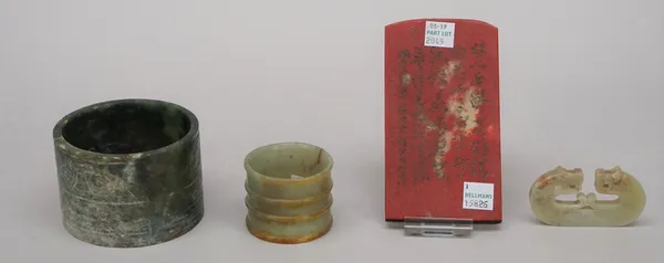 A Chinese archaistic spinach jade cylinder, carved with panels of taotie masks, 6cm. high; also a smaller celadon and russet jade ribbed cylindrical h