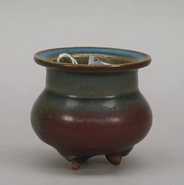 A small Chinese junyao tripod censer, of cauldron form raised on three peg feet, the blue glaze with purple splashes, 7cm. high.