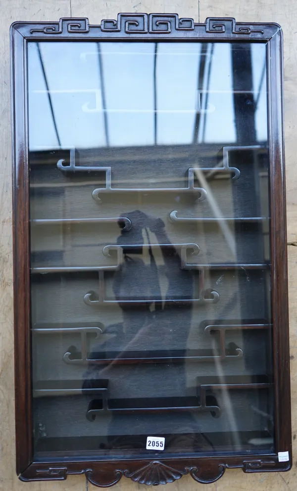 A Chinese hardwood and glass hanging display cabinet, fitted with an arrangement of shelves with scroll ends, 83cm. by 49cm.