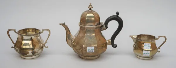 A silver three piece tea set, comprising; a teapot, a twin handled sugar bowl and a milk jug, each piece of bombe octagonal form, the teapot with a bl