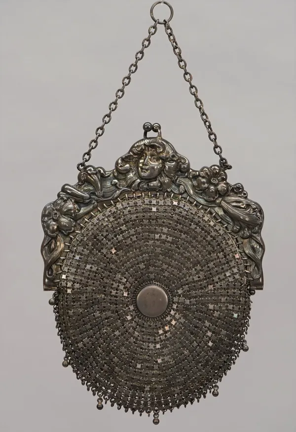 A lady's silver mounted purse, having a textile lining, the mount embossed with flowers, a lady's face and foliate scrolls, in the Art Nouveau taste,