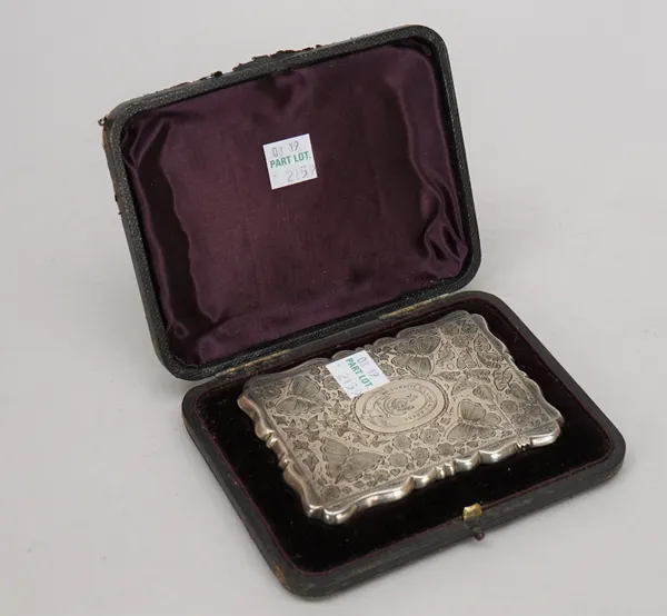 A Victorian silver shaped rectangular visiting card case, the exterior engraved with butterflies, flowers and leaves, with an engraved crest and motto