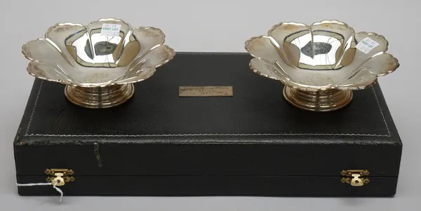 A pair of silver bonbon dishes, each of octagonal flowerhead form, engraved to the centre with the Avon logo, raised on a circular foot, Birmingham 19