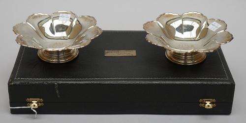 A pair of silver bonbon dishes, each of octagonal flowerhead form, engraved to the centre with the Avon logo, raised on a circular foot, Birmingham 19