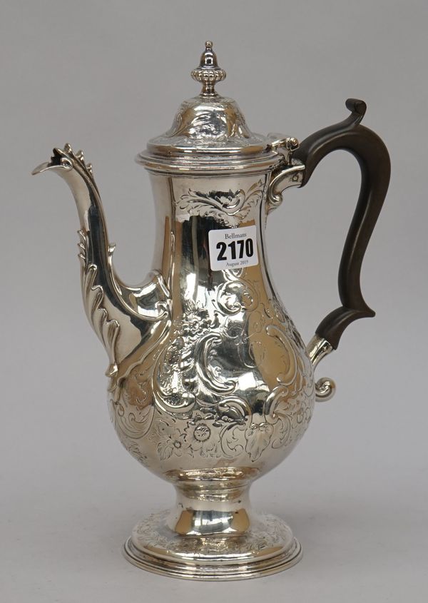 A George III silver coffee pot, of baluster form, the body with later floral, scroll and foliate embossed decoration, raised on a circular foot, with