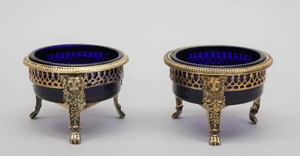 A Victorian silver gilt salt, of circular form, with pierced decoration, raised on three paw feet, London 1846 and another salt, in a similar design,