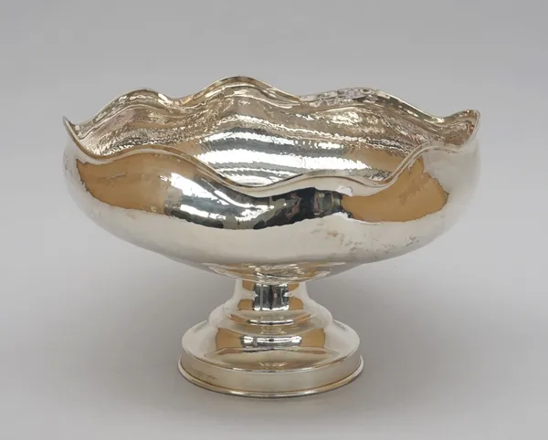 A silver pedestal bowl, having a beaten finish below a wavy rim, raised on a circular foot, detailed indistinctly 925, diameter 24cm, weight 482 gms.