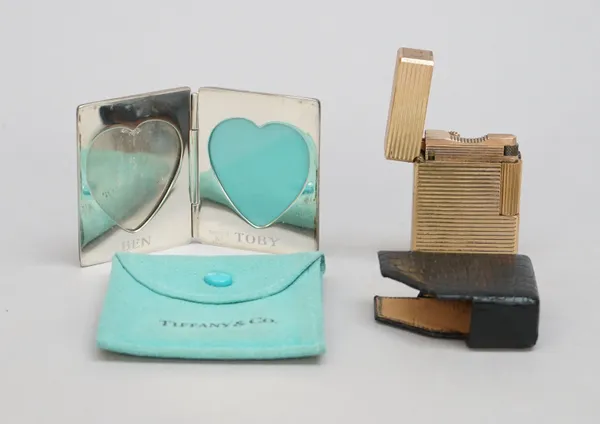 A Tiffany & Co Sterling silver twin compartment photograph frame, with heart shaped apertures and a Dupont Paris gilt metal rectangular gas lighter, i