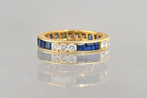 A gold, sapphire and diamond full eternity ring, mounted with rows of calibre cut sapphires, alternating with rows of circular cut diamonds, ring size
