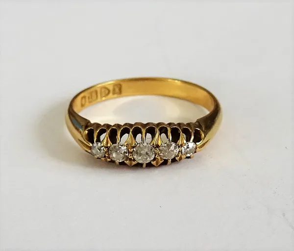 An 18ct gold and diamond set five stone ring, mounted with a row of cushion shaped diamonds, graudating in size to the centre stone, Chester 1910, rin