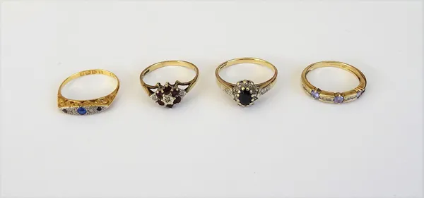 An 18ct gold, diamond and blue gem set ring, Chester 1927, a 9ct gold, sapphire and diamond set oval cluster ring, a 9ct gold ruby and diamond set clu