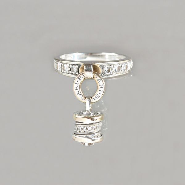 A lady's B Zero diamond set white gold ring by Bvlgari, set with brilliant cut diamonds, suspending a cylindrical pavé set diamond charm, from a hoop